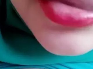 A dame wearing a hijab gives herself a